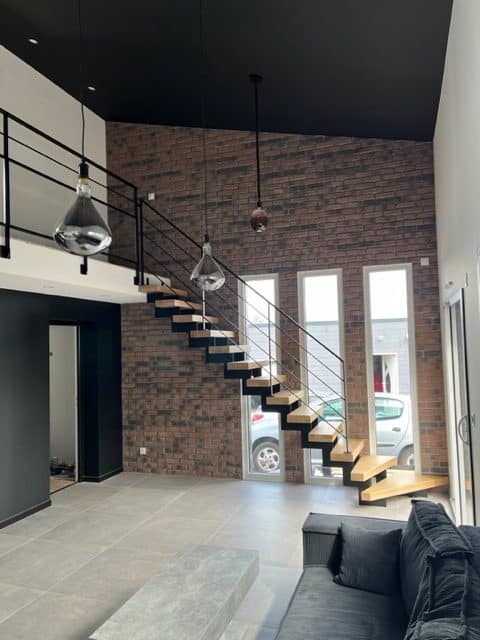 Escaliers Design 14 a récemment réalisé un projet près de Caen : un escalier sur mesure en acier thermolaqué noir avec des marches en chêne.